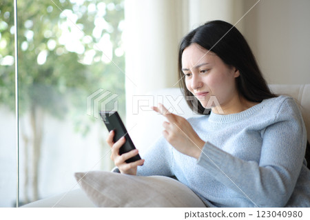 Worried asian woman crossing fingers checking phone 123040980
