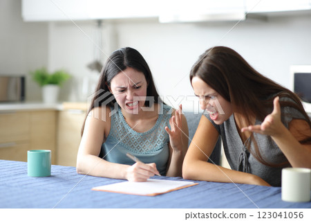 Angry roommates reading paper contract Angry roommates reading paper contract 123041056