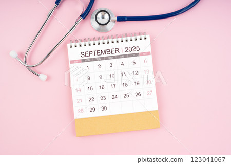 September 2025 desk calendar and Medical stethoscope on pink background. September 2025 desk calendar and Medical stethoscope on pink background. 123041067