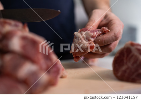A skilled chef is meticulously preparing fresh and flavorful meat cuts for culinary dishes 123041157