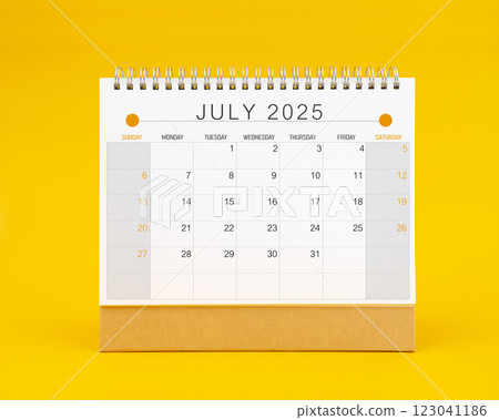 July 2025 desk calendar on yellow color background. July 2025 desk calendar on yellow color background. 123041186