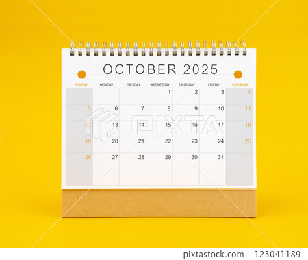 October 2025 desk calendar on yellow color background. October 2025 desk calendar on yellow color background. 123041189
