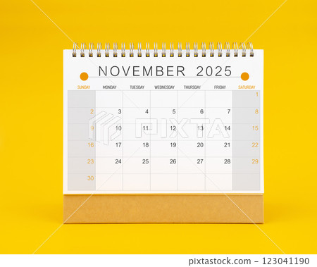 November 2025 desk calendar on yellow color background. 123041190