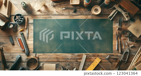 Top-down view of a cluttered workbench with a green cutting mat and various crafting tools, ideal for DIY projects 123041364