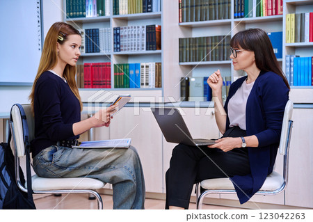 Counselor working with teenage girl high school student in office educational building 123042263