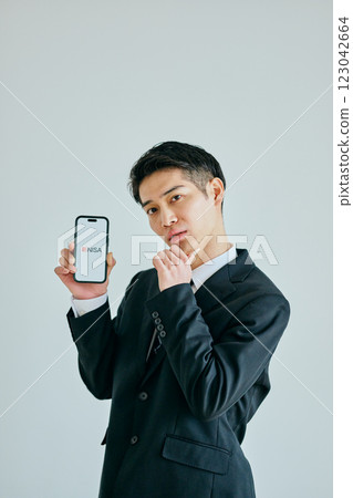 A young man in his 20s holding a smartphone New NISA 123042664