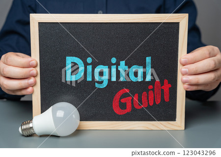 A man holds a sign that says Digital Guilt. Consequences of technology, social media overuse. Privacy concerns, and ethical issues in the digital age. 123043296
