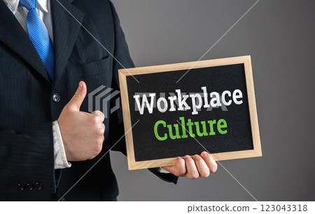 Businessman holding sign with Workplace Culture and giving thumbs up in approval. Positive company environment, teamwork, corporate values, employee engagement. Office morale. 123043318