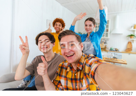 Cheers Funky mood. Happy friends make selfie. Man taking photo of friends at party. Group of multiracial people taking photo on phone. Young people enjoy their company smile have fun. Webcamera view Cheers Funky mood. Happy friends make selfie. Man taking photo of friends at party. Group of multiracial people taking photo on phone. Young people enjoy their company smile have fun. Webcamera view 123043627