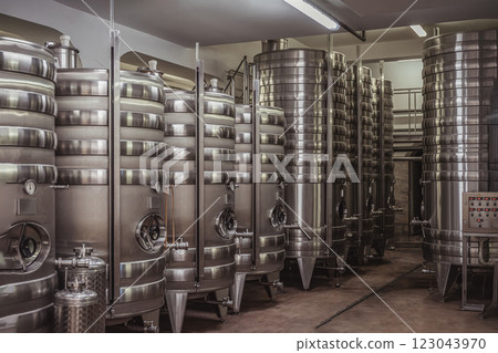 Large stainless steel fermentation tanks inside a modern winery. Industrial equipment for wine production and storage 123043970