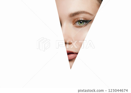 girl with beautiful bright green eyes with shining shadows, looks into the hole of white paper girl with beautiful bright green eyes with shining shadows, looks into the hole of white paper 123044674
