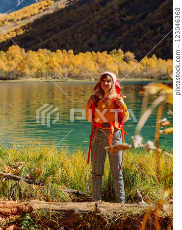Cheerful hiker woman nearly lake in autumnal mountains. 123046368