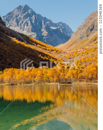 Mountain lake with glassy surface on water and autumnal trees. 123046369