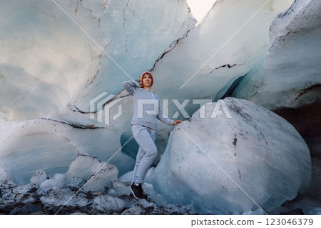 Hiker woman staying under ice glacier. Glacier and female tourist 123046379