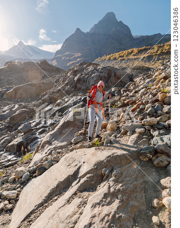 Hiker woman with backpack trekking in rocky mountains. Hiker woman with backpack trekking in rocky mountains. 123046386