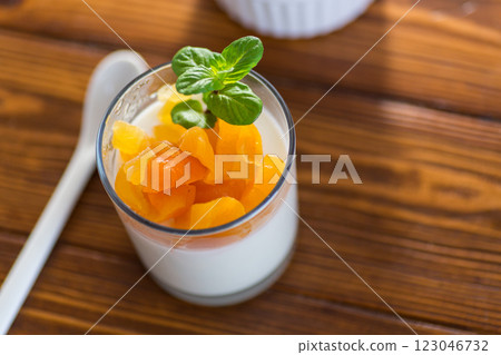 Light fruit yogurt with dried apricots on dark wooden table 123046732