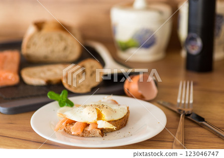 A slice of bread with lightly salted red fish and a cooked egg for breakfast 123046747