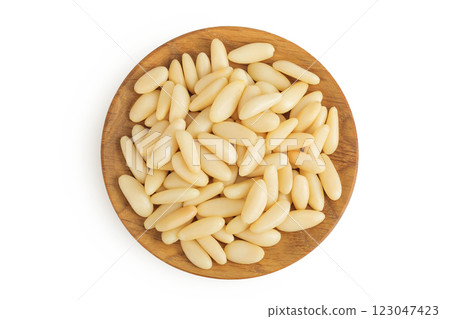 Shelled European pine nuts in wooden bowl isolated on white background with full depth of field. Top view. Flat lay 123047423