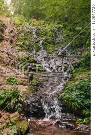Woman Tourist Enjoying Mountain Waterfall in Forest 123047720