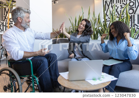 Diverse group of professionals including man in wheelchair, brainstorming ideas for business Diverse group of professionals including man in wheelchair, brainstorming ideas for business 123047830