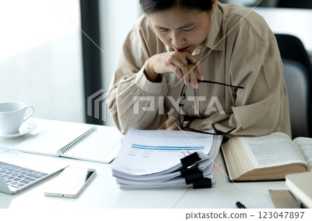 Elder businesswoman in casual attire is thinking while sitting 123047897