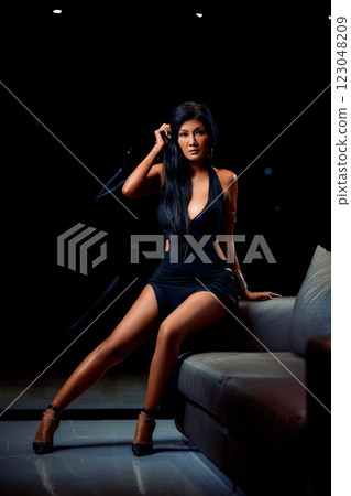 Sexy asian girl in black dress posing on sofa Sexy asian girl in black dress posing on sofa 123048209