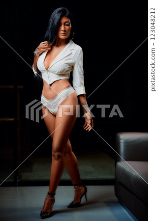 Sexy asian girl in white bikinin and jacket posing near to sofa 123048212