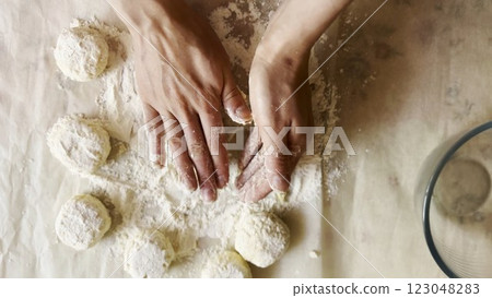Female hands sculpting cottage cheese pancakes on cuisine table. Arms of young woman preparing tasty breakfast on desk. Process of making cheesecakes in home kitchen. Cooking healthy food concept Female hands sculpting cottage cheese pancakes on cuisine table. Arms of young woman preparing tasty breakfast on desk. Process of making cheesecakes in home kitchen. Cooking healthy food concept 123048283