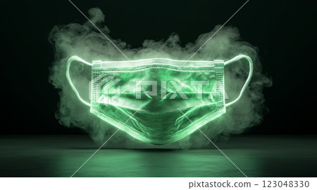 Glowing green medical mask surrounded by smoke on dark background. 123048330