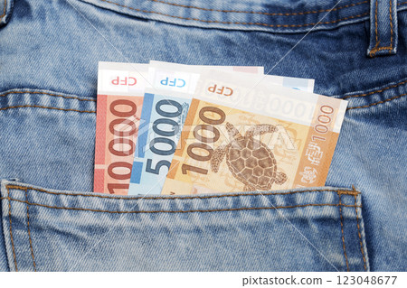 CFP franc in the pocket of blue jeans CFP franc in the pocket of blue jeans 123048677