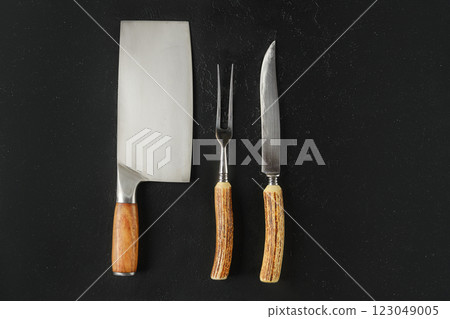 Versatile kitchen utensils on a dark background for culinary preparation and presentation 123049005
