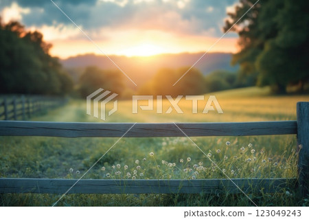 sunset field with wooden fence in glowing evening light featuring soft focus meadow and distant hills calm mood copyspace concept of travel, environment, marketing 123049243