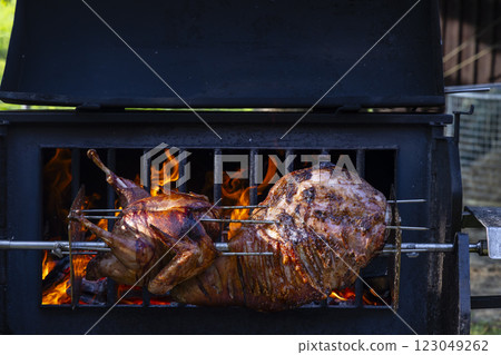 Roasting pork and turkey on spit Roasting pork and turkey on spit 123049262
