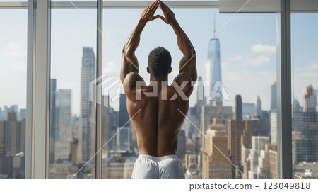 Muscular figure stretching in a modern high-rise apartment with a breathtaking city skyline view at sunrise. Generative AI 123049818