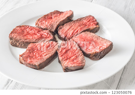 Perfectly sliced medium-rare fillet mignon steak served on a white plate Perfectly sliced medium-rare fillet mignon steak served on a white plate 123050076