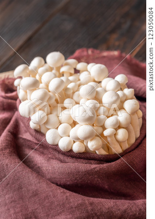 Fresh white beech mushrooms elegantly arranged in textile 123050084
