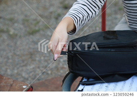 Girl Puts The Musical Instrument Ukulele In The Case Outdoor In Park 123050246