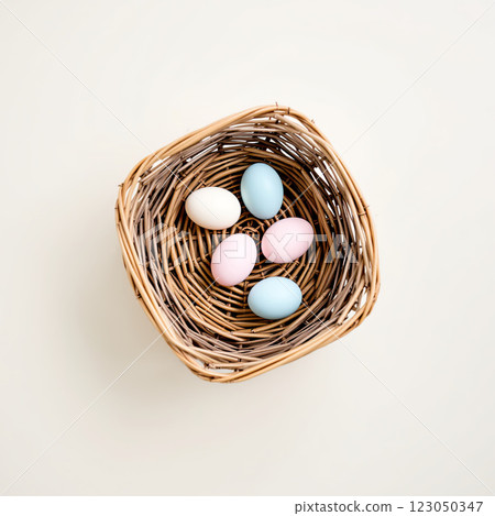 Colorful Eggs in a Woven Basket Resting on a Light Surface for a Festive Spring Celebration 123050347