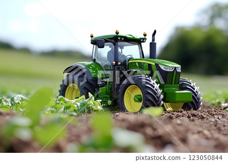 Green tractor working in agricultural field on sunny day 123050844