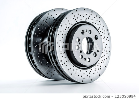 Two performance cross-drilled brake rotors resting on white background Two performance cross-drilled brake rotors resting on white background 123050994