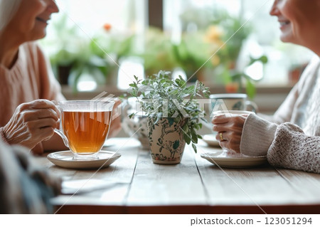 Two elderly women enjoying tea together 123051294