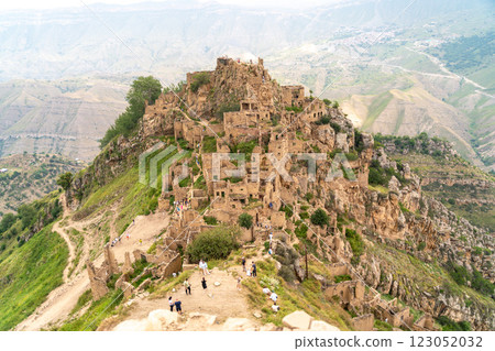 Dagestan Gamsutl. Ancient ghost town of Gamsutl old stone houses in abandoned Gamsutl mountain village in Dagestan, Abandoned etnic aul, summer landscape. 123052032