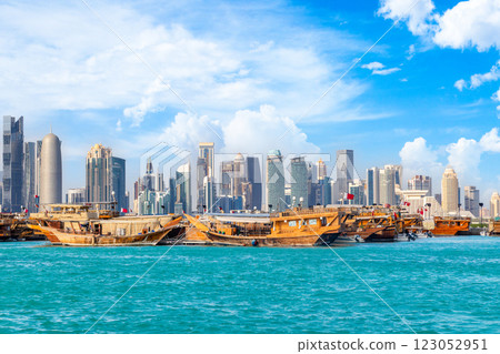 Traditional arab dhow fishermen boats at the sea bay with Doha futuristic business downtown center skyscrapers 123052951