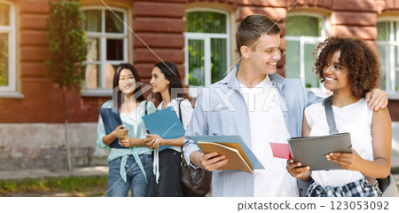College Romance. Portrait of smiling male student cuddling his african american girlfriend outdoors during break in classes 123053092