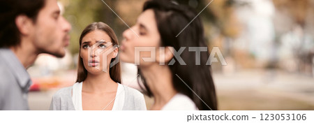 Infidelity. Girl Looking At Her Cheating Boyfriend Kissing Dating With Other Woman In Park Outdoors. Selective Focus 123053106