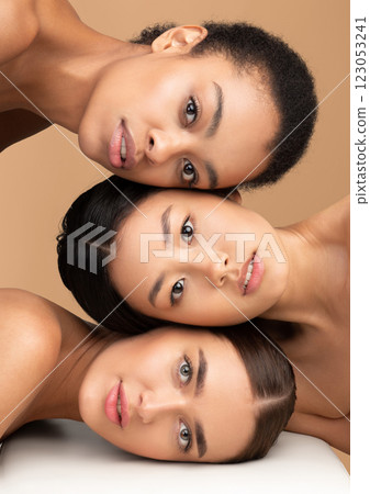 Female Beauty. Portrait Of Three Attractive Women Models With Perfect Soft Face Skin Looking At Camera Over Beige Studio Background Female Beauty. Portrait Of Three Attractive Women Models With Perfect Soft Face Skin Looking At Camera Over Beige Studio Background 123053241