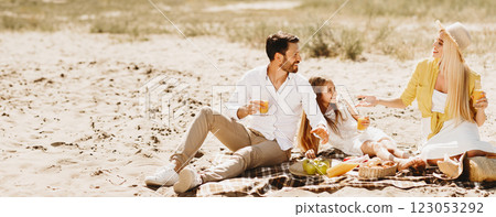 Family Having Summer Picnic Sitting On Blanket Talking And Eating Enjoying Sunny Day Outdoors In Countryside. Summertime Leisure And Vacation Family Having Summer Picnic Sitting On Blanket Talking And Eating Enjoying Sunny Day Outdoors In Countryside. Summertime Leisure And Vacation 123053292