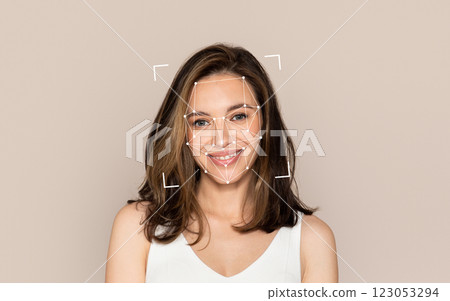 A young woman smiles while a facial recognition overlay appears around her face. 123053294