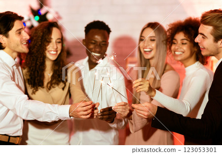 Happy New Year. Millennial Friends Celebraing Christmas Burning Sparklers Standing Indoors, Focus On Bengal Lights. Happy New Year. Millennial Friends Celebraing Christmas Burning Sparklers Standing Indoors, Focus On Bengal Lights. 123053301