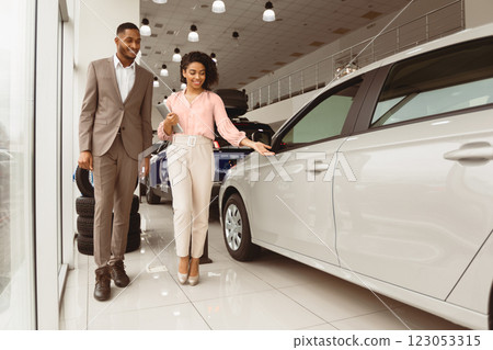 Automobile Sales. African Businessman Choosing Luxury Car With Auto Seller In Dealership Showroom. Empty Space For Text Automobile Sales. African Businessman Choosing Luxury Car With Auto Seller In Dealership Showroom. Empty Space For Text 123053315